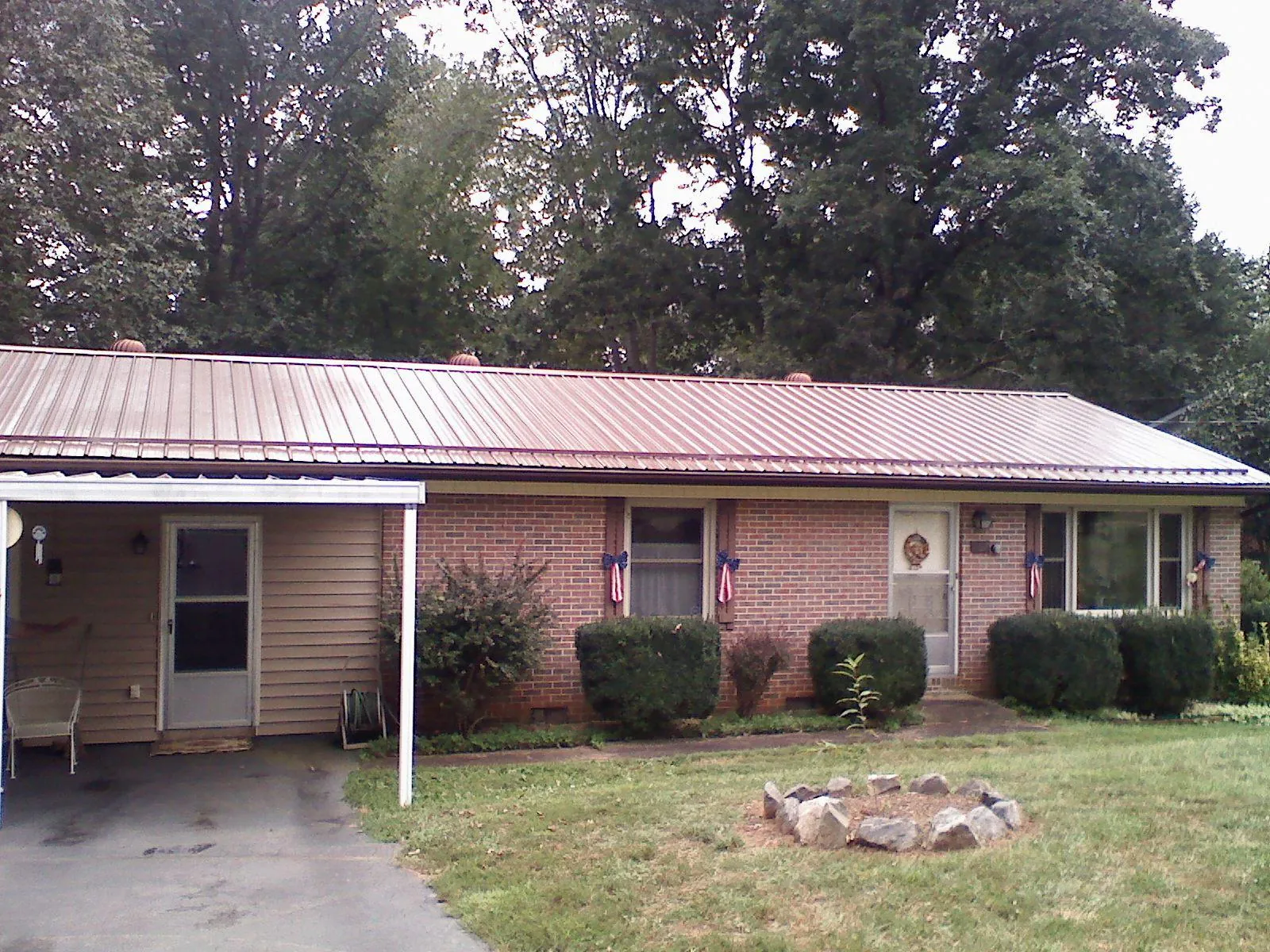 Bronze metal roof and carport on a brick ranch home — Roof Repair work by our crew in Harwich